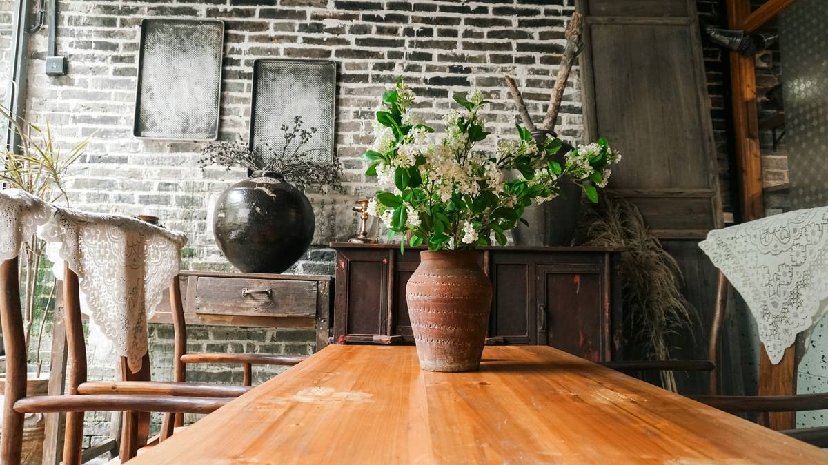home goods table centerpieces featuring low floral arrangement with candles and eucalyptus on wooden dining table