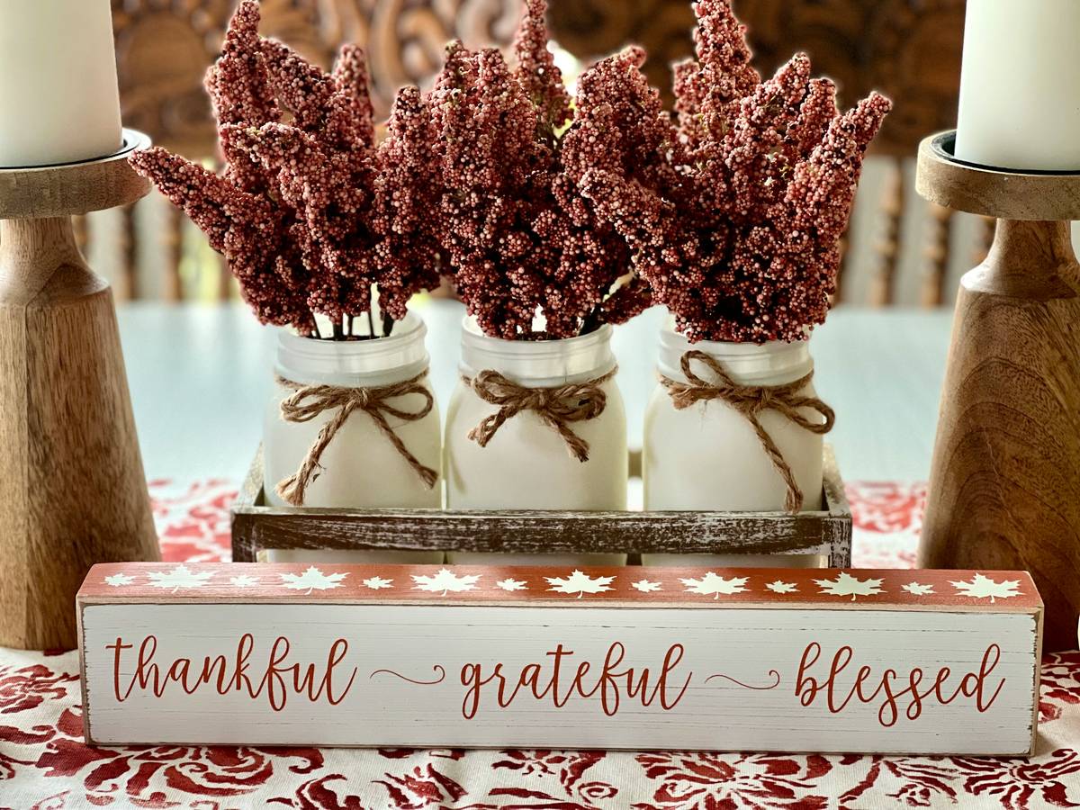 how to make centerpieces for tables using seasonal flowers and vintage glassware on a wooden dining table