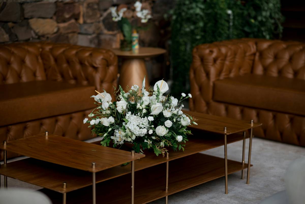centerpiece ideas for home decor featuring a low wooden tray with candles, eucalyptus, and ceramic bowls